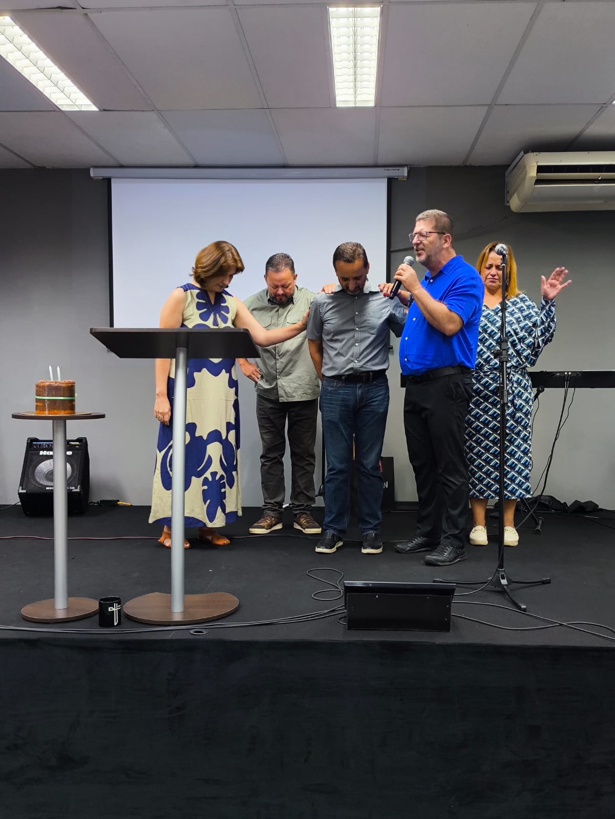 Pastores da YAH Church orando pela igreja durante o culto