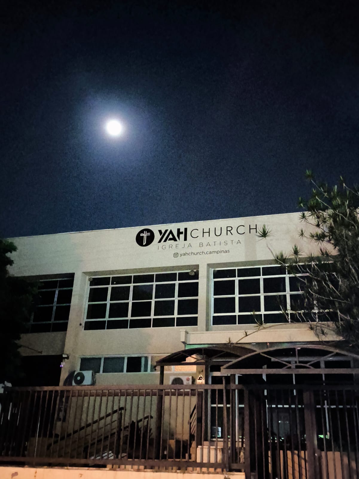 Fachada da YAH Church Campinas à noite, com a placa Igreja Batista